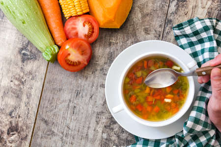 Vegetable soup in bowl on wooden table. Top viewの写真素材