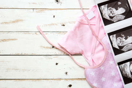 Pink baby break and ultrasound on white wooden background.Copyspaceの写真素材