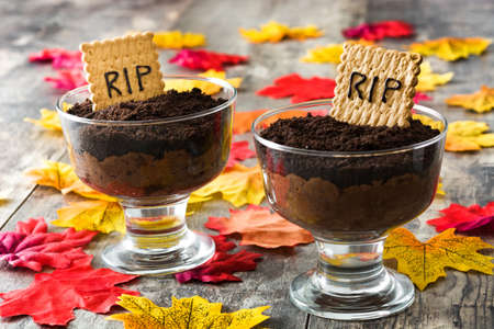 Funny Halloween chocolate mousse with tomb cookie on wooden tableの写真素材