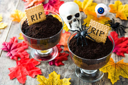 Funny Halloween chocolate mousse with tomb cookie on wooden tableの写真素材
