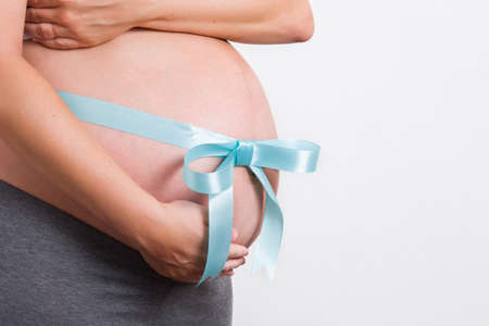 Pregnant woman with ribbon tied around her belly