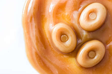Toffee caramel candy and caramel sauce isolated on white background. Copyspace.
