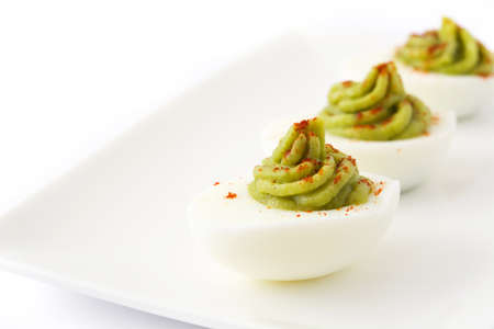 Stuffed eggs with guacamole isolated on white backgroundの写真素材