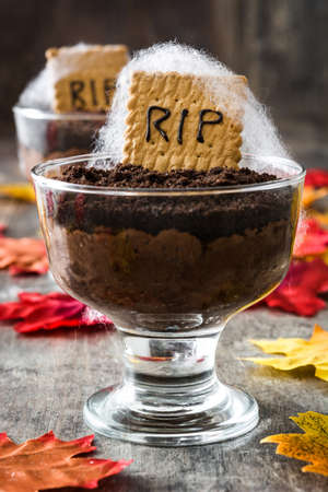 Funny Halloween chocolate mousse with tomb cookie on wooden tableの写真素材