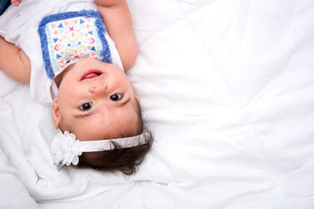 Beautiful baby girl on a bedの写真素材