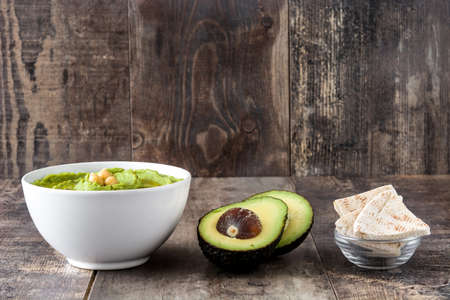 Avocado hummus in bowl on wooden table