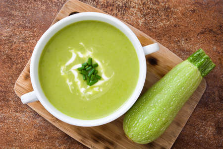 zucchini soup in bowl on brown background. Top viewの写真素材