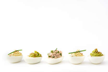 Variety of stuffed eggs with avocado and tuna isolated on white backgroundの写真素材
