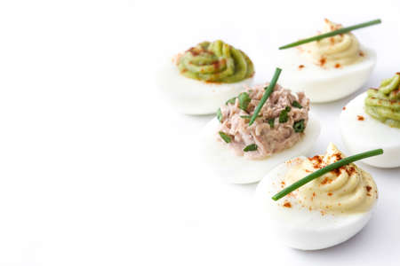Variety of stuffed eggs with avocado and tuna isolated on white background