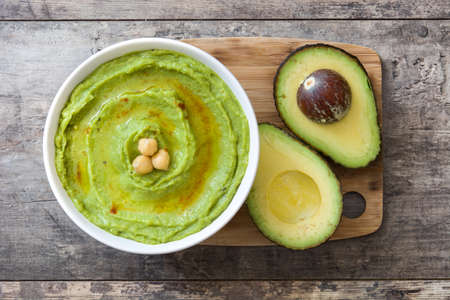 Avocado hummus in bowl on wooden table.Top viewの写真素材