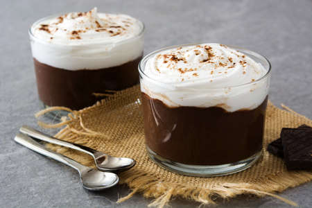 Chocolate mousse with cream in glass on gray stoneの写真素材