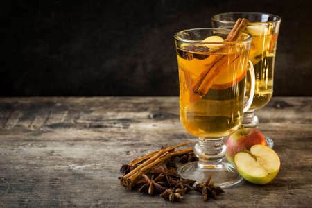 Mulled cider in glass on wooden table copyspace. Christmas drink
