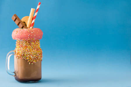 Extreme milkshake or freak shake on blue background.Copyspace