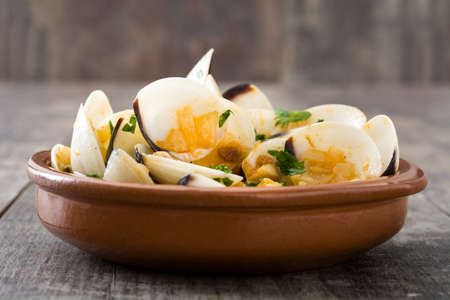 Clams with marinera sauce.Almejas a la marinera. Spanish recipe on wooden tableの写真素材