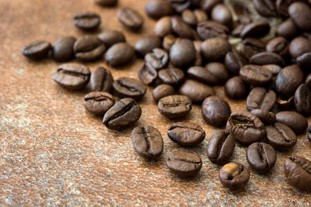 Roasted coffee beans on brown rustic background