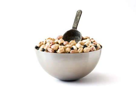 Uncooked assorted legumes with spoon in metal bowl isolated on white background.の写真素材