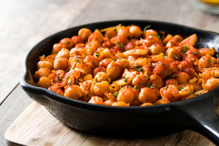 Fried spicy chickpeas in frying pan on wooden tableの写真素材