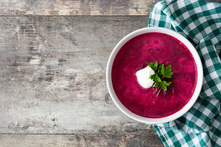 Beet soup in white bowl on wooden table. Top view copyspaceの写真素材
