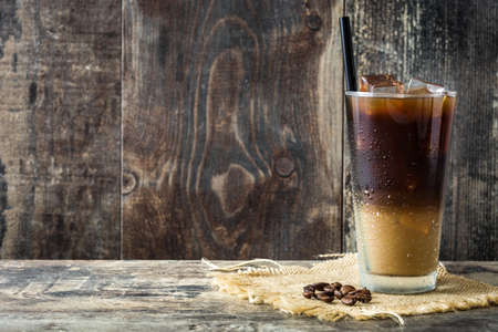 Iced coffee in glass on wooden table. Copyspaceの写真素材
