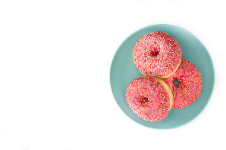 Pink frosted donut with colorful sprinkles. Isolated on white background. Top view Copyspaceの写真素材