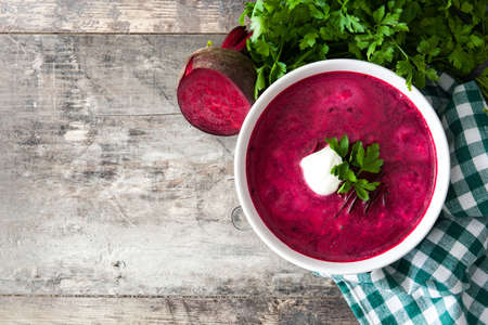 Beet soup in white bowl on wooden table. Top view Copyspaceの写真素材