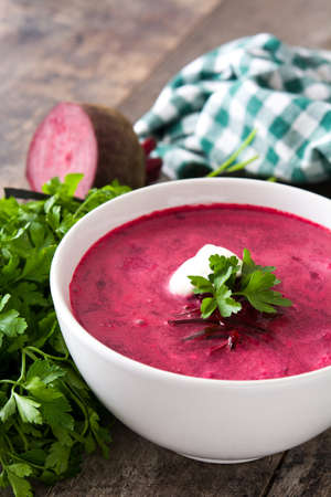 Beet soup in white bowl on wooden tableの写真素材