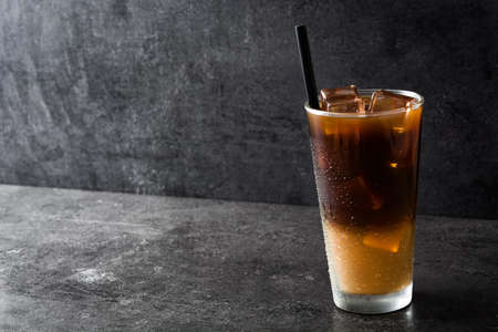 Iced coffee in glass on black stone. Copyspaceの写真素材