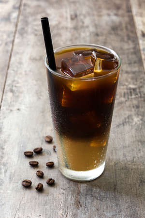 Iced coffee in glass on wooden table.