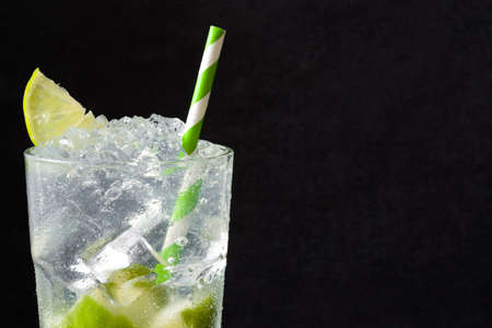 Caipirinha cocktail in glass on black stone. Copyspaceの写真素材