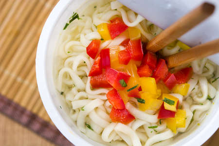 Take away noodles with vegetables on wooden table. Top viewの写真素材