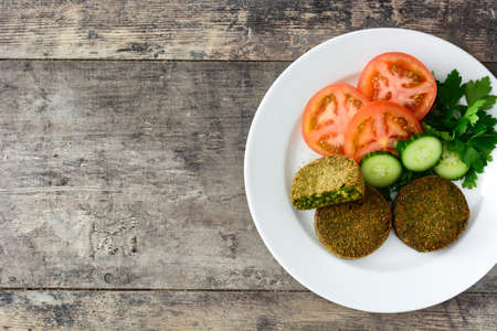 Grilled veggie hamburger with spinach and peas on wooden table. Top view Copyspaceの写真素材