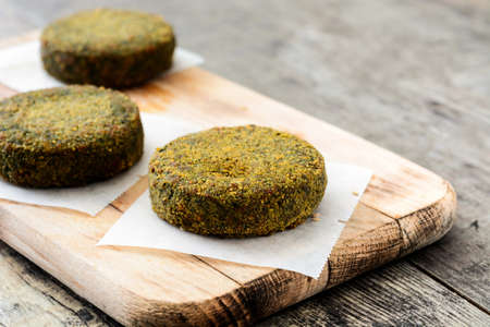 Grilled veggie hamburger with spinach and peas on wooden table. Copyspace