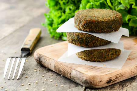 Grilled veggie hamburger with spinach and peas on wooden table