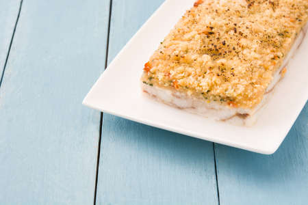 White fish casserole with cheese on blue wooden background. Copyspaceの写真素材