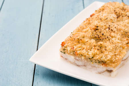 White fish casserole with cheese on blue wooden background. Copyspaceの写真素材