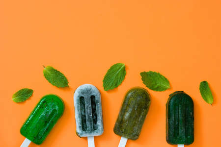 Green frozen ice cream on orange background. Top view Copyspaceの写真素材