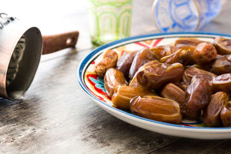 Dates food in plate and tea on wooden tableの写真素材