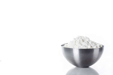 Fresh cottage cheese in a metal bowl isolated on white background. Copyspace