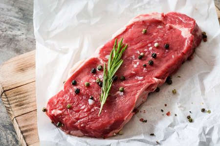 Raw beef steak with spicy ready to be cooked on wooden table.