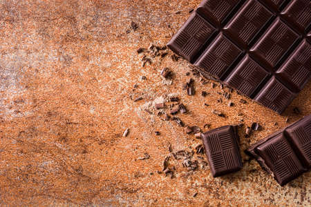 Black chocolate pieces on brown background.Top view. Copyspaceの写真素材