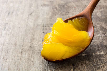 Ghee or clarified butter on wooden spoon on wooden table. Copyspaceの写真素材
