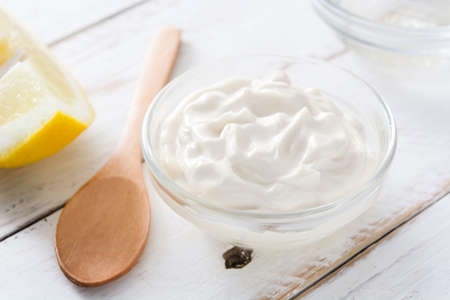 Sour cream in crystal bowl on wooden table