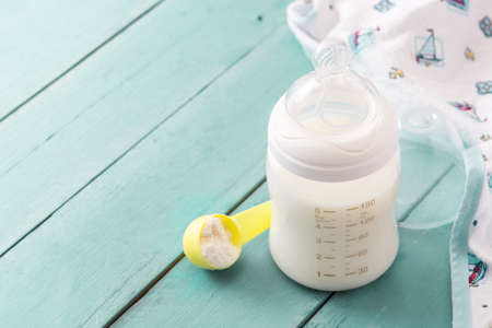 Baby bottle and milk on blue wooden table. Copyspaceの写真素材