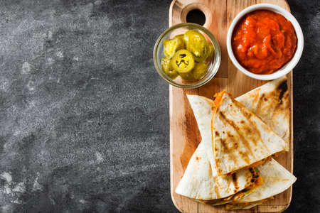 Mexican quesadilla with chicken, cheese and peppers on black slate. Top view Copyspaceの写真素材