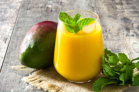 Mango Lassi dessert. Traditional Indian drink on wooden table.の写真素材