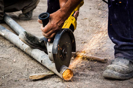 Worker cutting metal pipe outdoorの写真素材