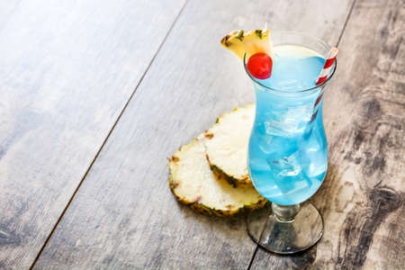 Blue Hawaiian cocktail on wooden table. Copyspaceの写真素材