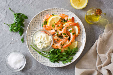 Grilled shrimps, parsley and lemon on gray stone. Top viewの写真素材