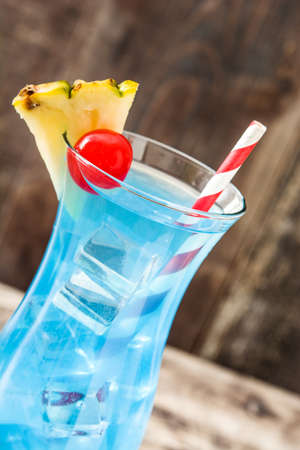 Blue Hawaiian cocktail on wooden table.の写真素材