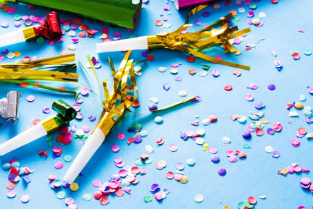 Party background. Party caps and confetti on blue background. Copyspace